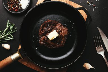 Tavada pirzola, biber, biberiye, tuz, sarımsak, bıçak, çatal, tereyağı