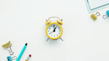 Beyaz arkaplanda ataç, mekanik saat, kalem, kalem ve not defteri. İş ve eğitim kavramı. Yüksek kalite fotoğraf