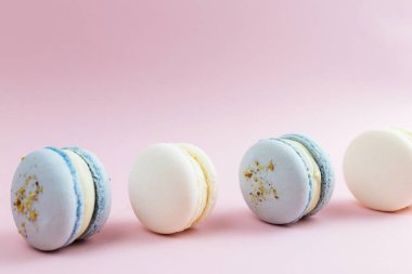 Masada beyaz ve mavi kurabiyeler, pembe arka planda badem kurabiyeleri. Yüksek kalite fotoğraf