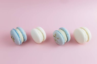 Masada beyaz ve mavi kurabiyeler, pembe arka planda badem kurabiyeleri. Yüksek kalite fotoğraf