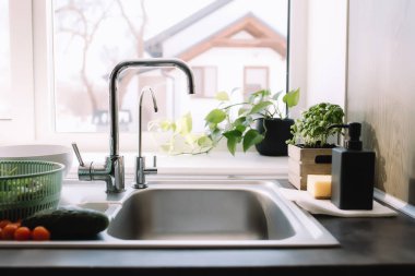 Lavaboda yıkanmaya hazır yeşil salata yaprakları, salatalık ve domates. Yüksek kalite fotoğraf