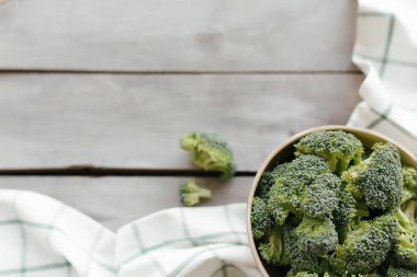 Tahta zemin üzerinde yeşil brokoli, beyaz havlu. Sağlıklı beslenme konsepti. Yüksek kalite fotoğraf