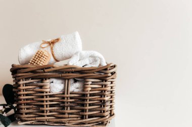 Banyo aksesuarlarıyla dolu bir sepet. Bir çift rulo ve katlanmış havlu, ayak fırçası. Ev kavramı. Otel temizliği konsepti. Yüksek kalite fotoğraf