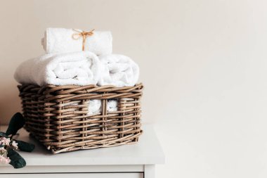 Banyo aksesuarlarıyla dolu bir sepet. Bir çift rulo ve katlanmış havlu. Otel temizliği konsepti. Yüksek kalite fotoğraf