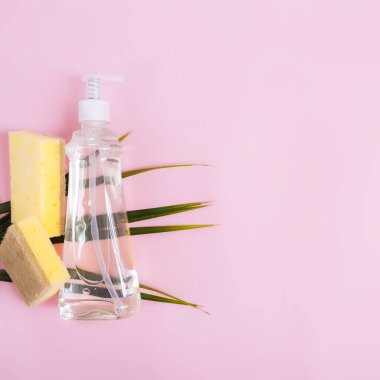 Yeşil palmiye yaprağı, sabun damlası, bulaşık deterjanı, bulaşık deterjanı, pastel pembe ve sarı arka planda bez. Yüksek kalite fotoğraf