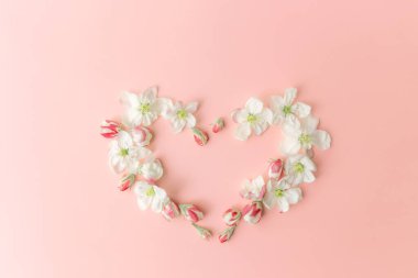 Tebrik kartı konsepti pembe arka planda, çiçek açan kalp şeklindeki süs çerçevesiyle yatıyordu. Yüksek kalite fotoğraf