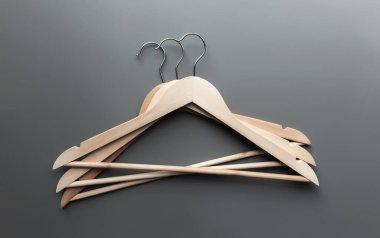 Kara Cuma ya da gri arka planda giyim endüstrisi konsepti düz katlanmış ahşap elbise askılarıyla yatıyordu.