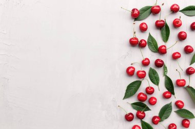 Tatlı kiraz çilekleri ve buz küpleriyle gri beton arka planda düz bir görünüm sergiliyordu. Tazelik, yaz kavramsal asgari arka plan. Fotokopi alanı ile eko, biyolojik tarım yiyeceği ve meyve konsepti