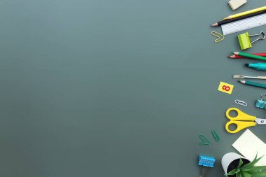 Okula geri dön kavramsal düz yeşil arka planda farklı ofis malzemeleri ile yatıyordu. İlkokul ve ortaokul öğrencisi konsepti. Makas, kalem, silgi, cetvel, not, klips.