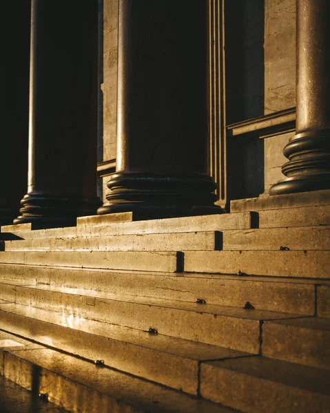 Batan güneşin ışınlarında altın mermer basamaklar ve kolonlar