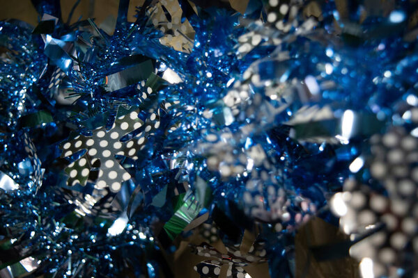 blue tinsel with various patterns in inserts. vintage. texture. horizontal. background. close up. Christmas. New Year. material for design. minimalistic. abstract. holiday symbols. holiday preparation