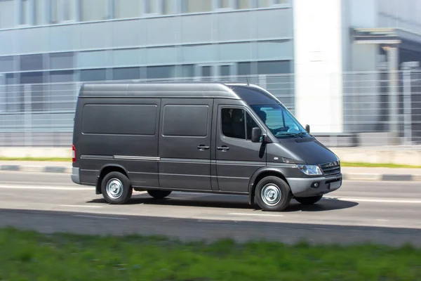 Gri minibüs şehir yolunda gidiyor.