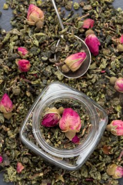 Gül tomurcukları ile yeşil çay yaprakları. 