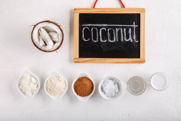 Coconut Products - coconut oil, water, milk, sugar, flakes and flour on white background. Top view.