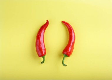 Sarı arka planda kırmızı biber. Üst görünüm, kopyalama alanı, düz döşeme, yakın çekim. Yiyecek konsepti.