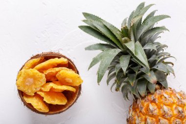 Kurutulmuş ananas halkaları ve beyaz arka planda taze ananas. Üst manzara, düz uzanma.