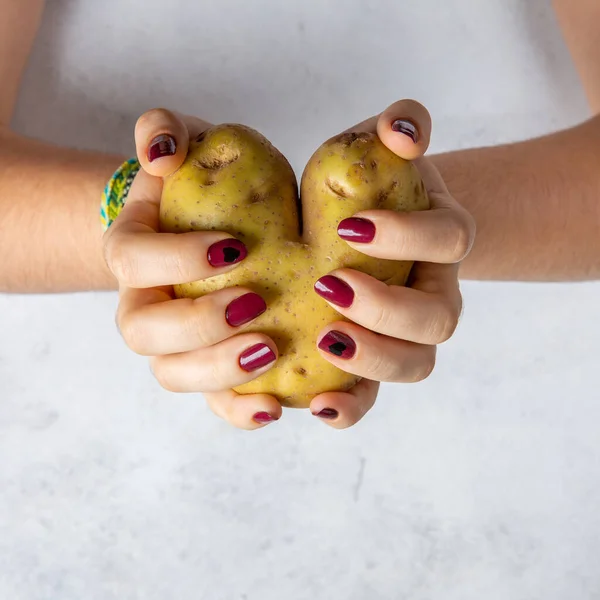 Ziemniak Kształcie Serca Rękach Kobiet Szarym Tle Przestrzeń Kopiowania — Zdjęcie stockowe