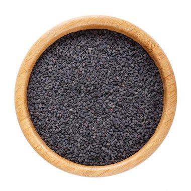 Tahta kasedeki siyah susam tohumları beyaz arka planda izole edilmiş. Üst görünüm.