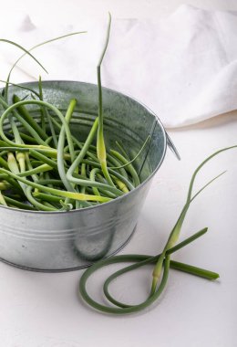 Beyaz üzerine metal kasede sarımsaklı oklar. Bir yığın taze taze sarımsak. Yiyecek malzemesi.. 