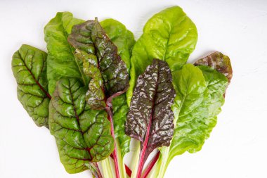 Beyaz arka planda bir sürü taze pazı yaprağı. Üst görünüm.