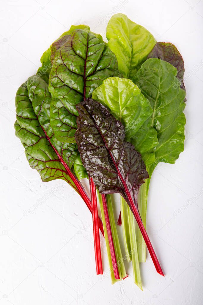 Bunch of fresh chard leaves on white background. Top view.