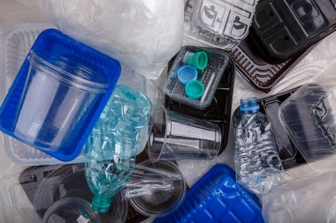 Plastic bottles and containers prepared for recycling. Waste management concept, environmental conservation.