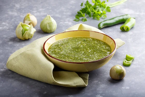 Domatesli salsa verde. Gri masada bir kase baharatlı yeşil sos, Meksika mutfağı.