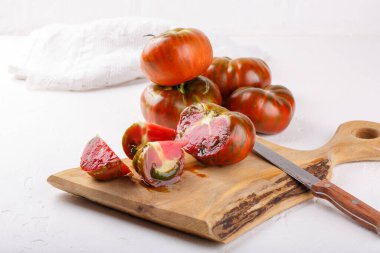 Beyaz arka planda olgun organik çizgili domatesler. Aile yadigarı domatesler. Tahta üzerinde siyah zebra..