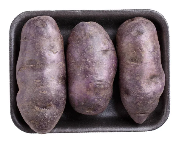Surowe Purpurowe Ziemniaki Czarnej Tacce Tworzywa Sztucznego Izolowane Białym Tle — Zdjęcie stockowe