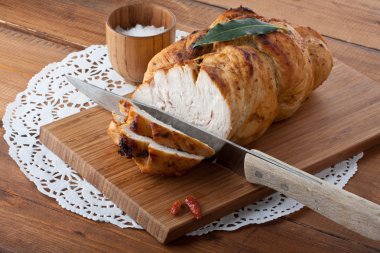 Roasted turkey breast on wooden plank clipart