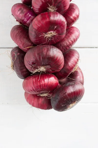 Dangling bunch of sweet red onion. — Stock Photo, Image