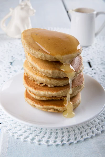 Stapel van zelfgemaakte volkoren pannenkoeken met een honing — Stockfoto