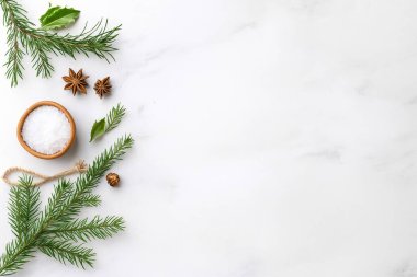 Çam dalları, yıldız anason, ahşap bir kasede deniz tuzu, kutsal yapraklar, ip ve hafif mermer bir arka planda dizilmiş çam kozalakları gibi doğal elementlerle bezenmiş bir tatil dairesi. Tatil kompozisyonu