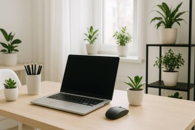 Minimalist İskandinav ev ofisi, dizüstü bilgisayarı açık ahşap bir masanın üzerinde, iç mekan bitkileriyle çevrili ve camdan gelen doğal ışıkla yıkanmış..