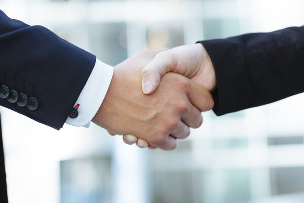 Two young business people shaking hands