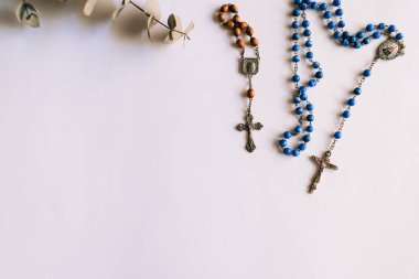 Beyaz arka planda dua edilecek iki tespih, biri küçük kahverengi ve diğeri büyük mavi. Boşluğu kopyala