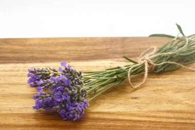 Ahşap zemin üzerinde lavanta pınarı ve yağ yapmak için cam bir şişe.