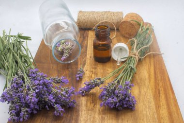 Ahşap zemin üzerinde lavanta pınarı ve yağ yapmak için cam bir şişe.