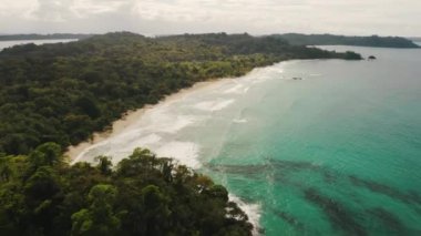 Panama, Bocas del Toro 'da beyaz kum, turkuaz deniz ve ormanlı güzel bir hava aracı manzarası.