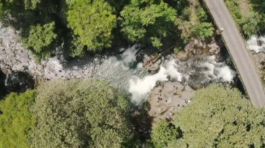 La Fortuna, Kosta Rika 'da nehrin keyfini çıkaran insanların bulunduğu ormanda hava taşması.