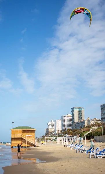 Sahilde elinde paraglider olan bir adam.