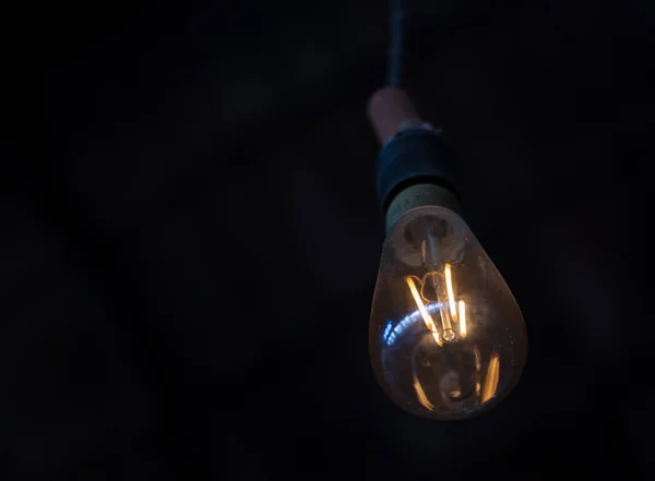 Karanlık bir odada parlayan bir lamba.