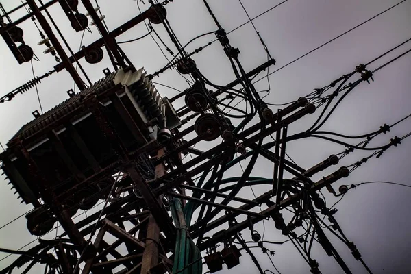 Bir trafo ve gökyüzüne karşı kablolar.