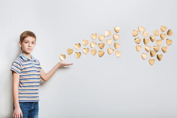 Ragazzo che tiene in mano cuori d'oro — Foto Stock