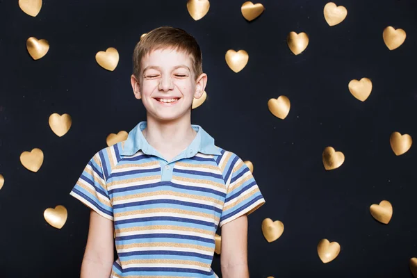 Boy skratta på gyllene hjärtan bakgrund — Stockfoto