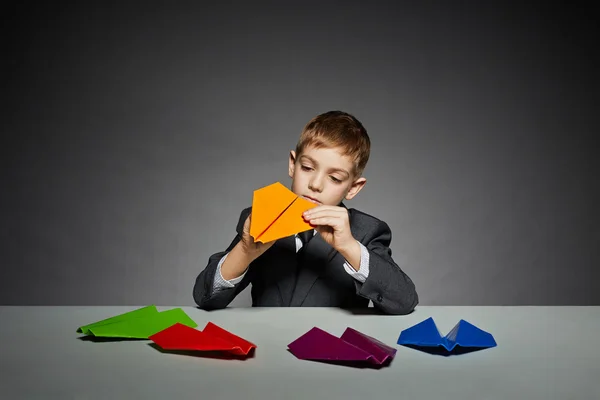 Niño de traje haciendo plano de papel amarillo —  Fotos de Stock