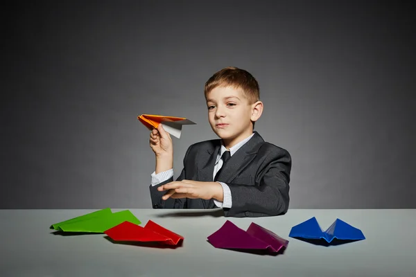 Niño de traje lanzando avión de papel amarillo —  Fotos de Stock