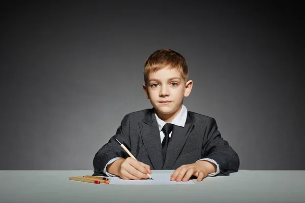 Boy in suit writing — Stock Photo, Image