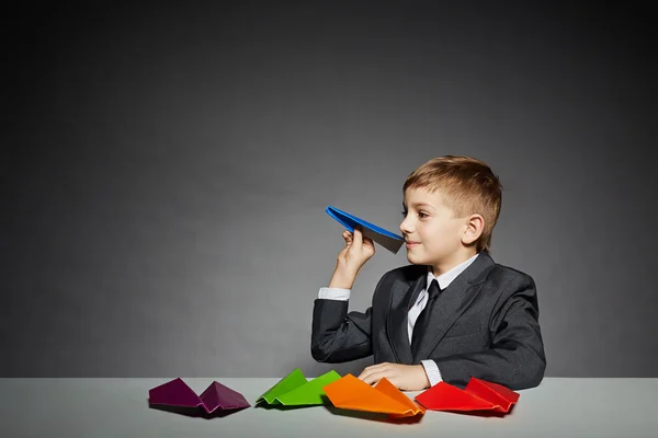 Chłopak w garniturze zamiar uruchomić kolor papieru samolot — Zdjęcie stockowe