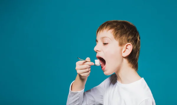 Garçon manger des pilules de cuillère — Photo